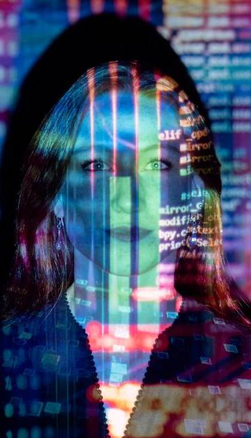 A woman with digital code projections on her face, representing technology and future concepts.