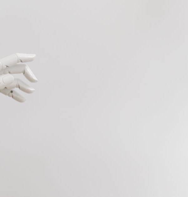 Minimalist image of a robotic hand reaching out on a white background.