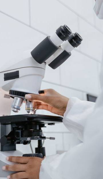Scientist using microscope for research in a modern laboratory setting.