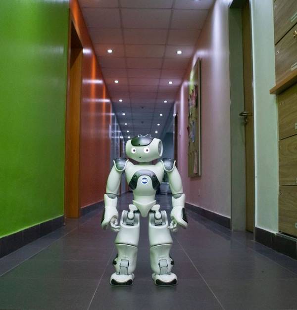 A humanoid robot stands in a vibrant, modern hallway in Lagos, Nigeria.