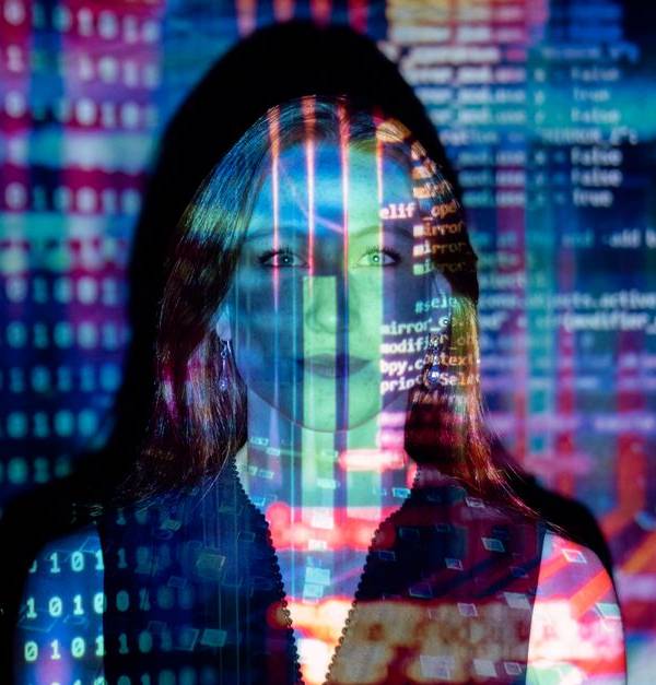 A woman with digital code projections on her face, representing technology and future concepts.