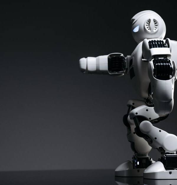 A white robot showcasing modern design on a sleek dark surface.