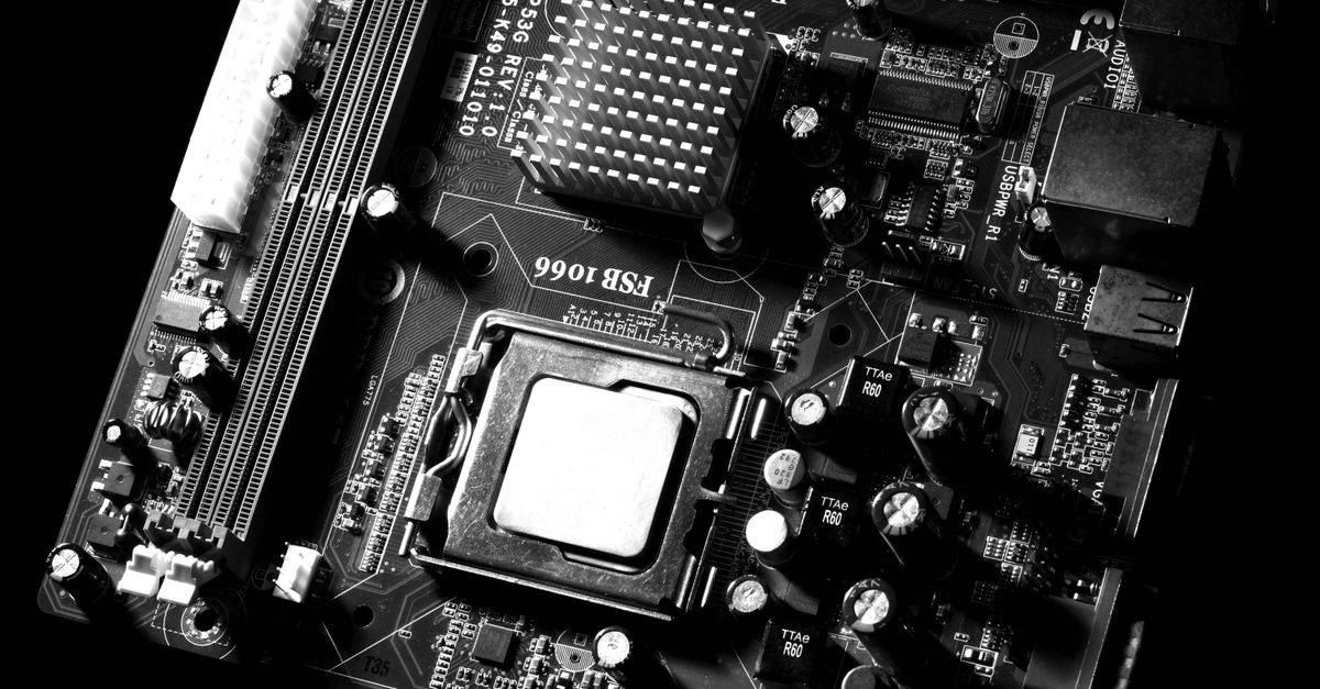 Monochrome detailed close-up of computer motherboard circuitry showcasing components and tech intricacies.