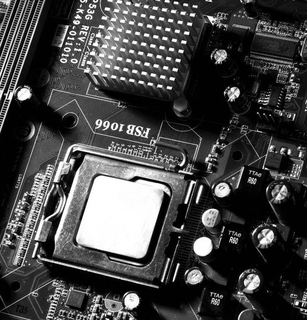 Monochrome detailed close-up of computer motherboard circuitry showcasing components and tech intricacies.