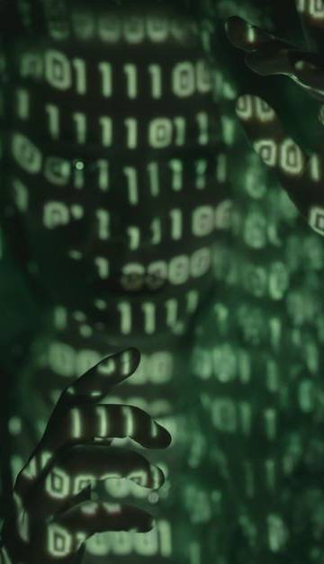 An unrecognizable person with binary code projected, symbolizing cybersecurity and digital coding.