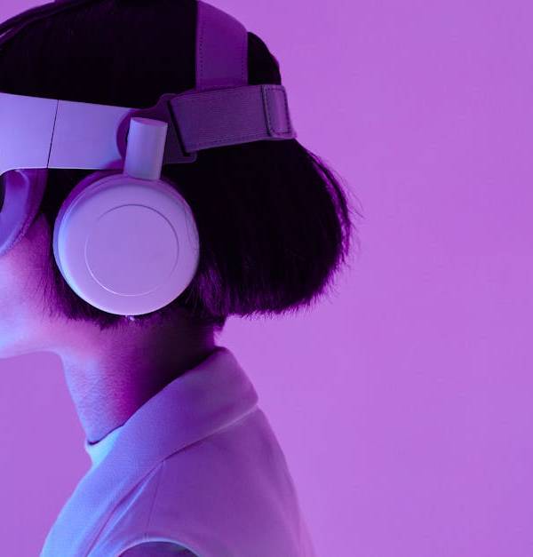 Side view of a woman wearing VR goggles in a purple-lit studio, highlighting modern technology.