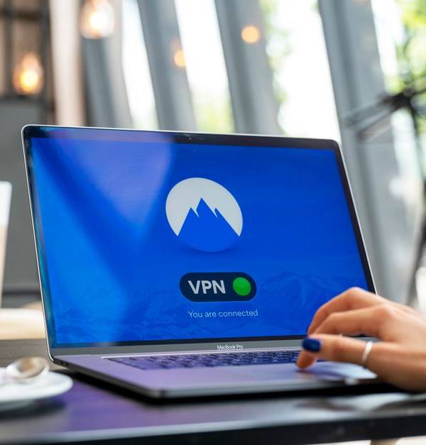 A person using a laptop with a VPN connection in a modern cafe setting, showcasing remote work and internet security.