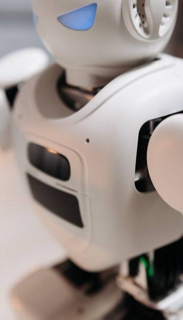 Close-up of a futuristic toy robot with blue eyes, showcasing modern technology indoors.
