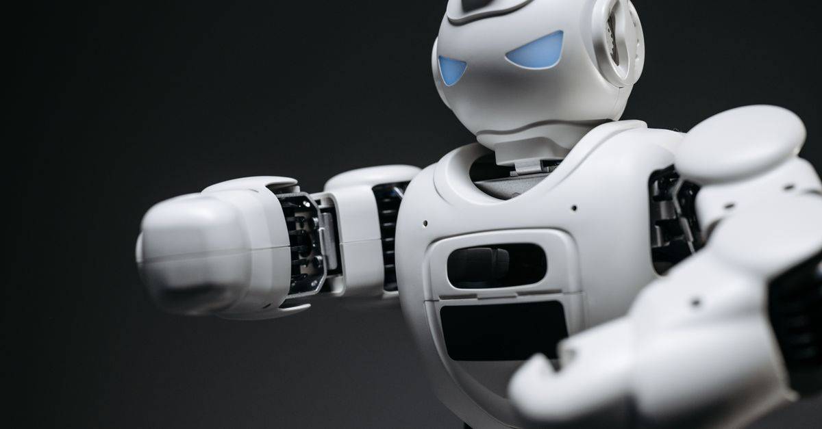 Detailed close-up of a high-tech white robot in a studio setting with a gray background.
