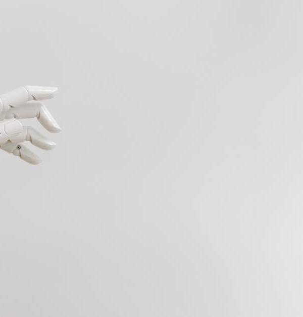 Minimalist image of a robotic hand reaching out on a white background.