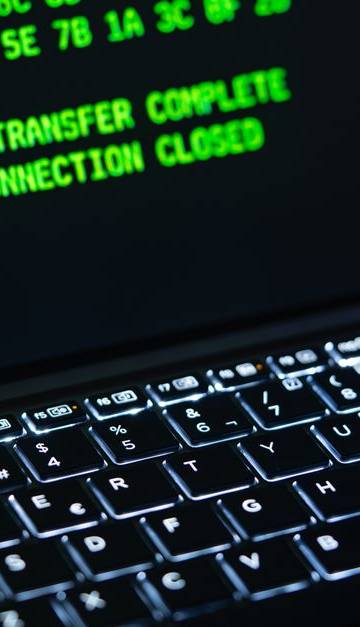 Close-up of a laptop screen displaying green code text. Perfect for cybersecurity themes.