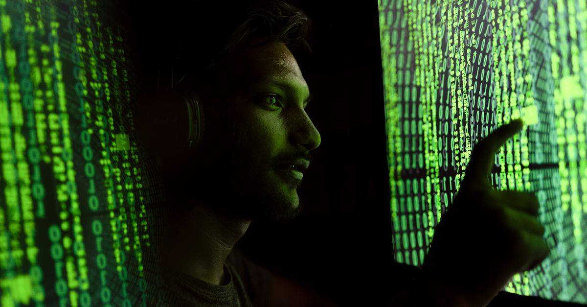 A person interacts with digital code on a screen, symbolizing cybersecurity technology.