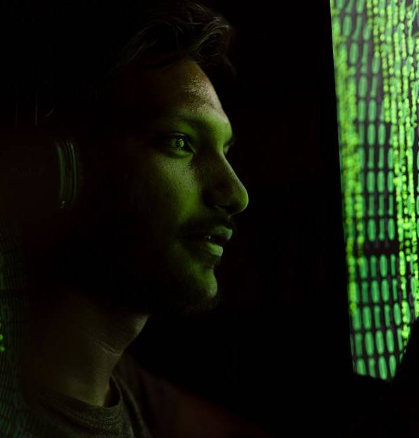 A person interacts with digital code on a screen, symbolizing cybersecurity technology.