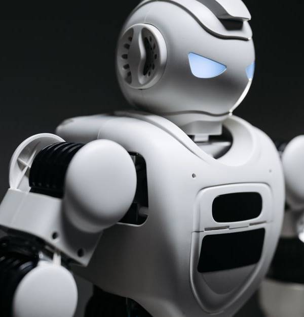 High-detail close-up image of a white robot with glowing eyes in studio lighting. Modern tech innovation.
