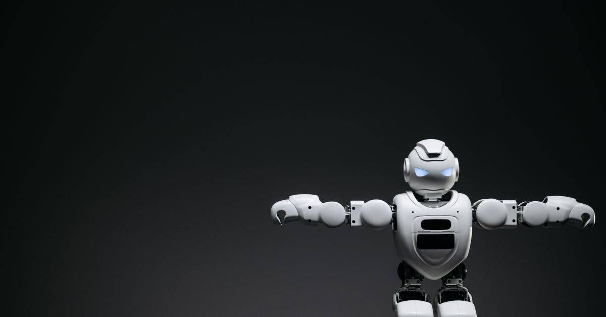 Studio shot of a humanoid robot with glowing eyes against a dark background, offering ample copyspace.