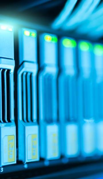 Detailed image of a server rack with glowing lights in a modern data center.