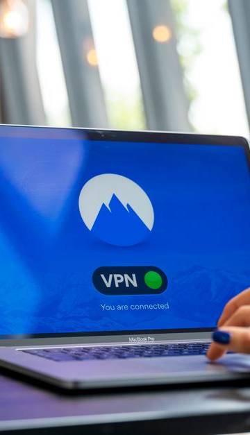 A person using a laptop with a VPN connection in a modern cafe setting, showcasing remote work and internet security.
