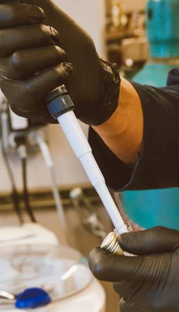 A lab technician performing an experiment with a pipette in a modern laboratory setting.