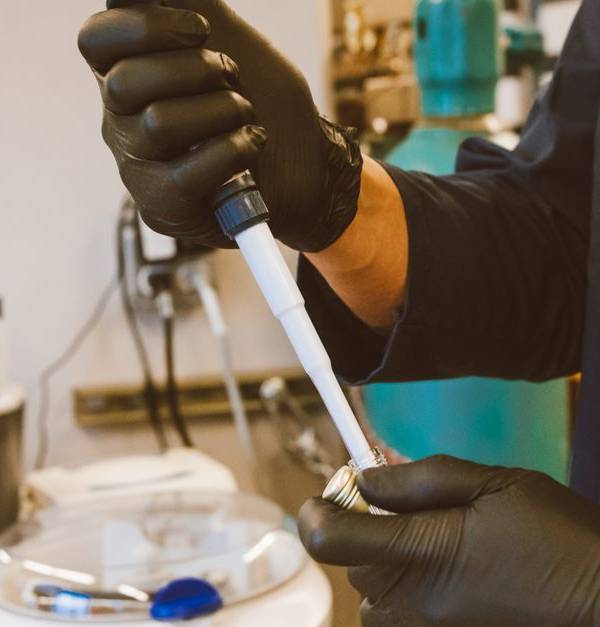 A lab technician performing an experiment with a pipette in a modern laboratory setting.