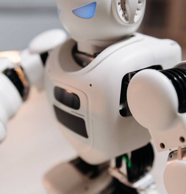 Close-up of a futuristic toy robot with blue eyes, showcasing modern technology indoors.