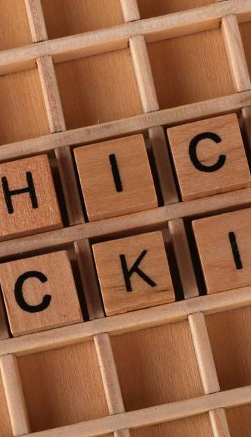 Wooden letter blocks spelling 'Ethical Hacking' on a grid background, symbolizing cybersecurity.