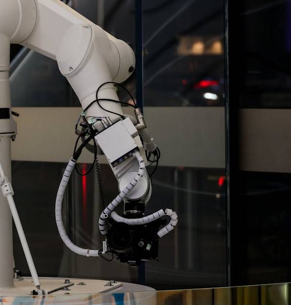 A white robotic arm operating indoors with a modern design and advanced technology.