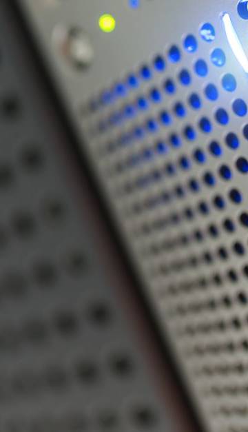 Focused detail of a modern server rack with blue LED indicators in a data center.