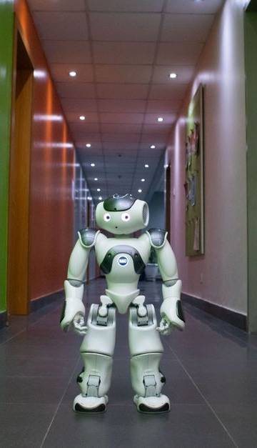 A humanoid robot stands in a vibrant, modern hallway in Lagos, Nigeria.