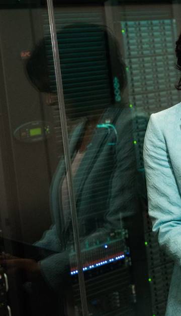 Female IT professional examining data servers in a modern data center setting.