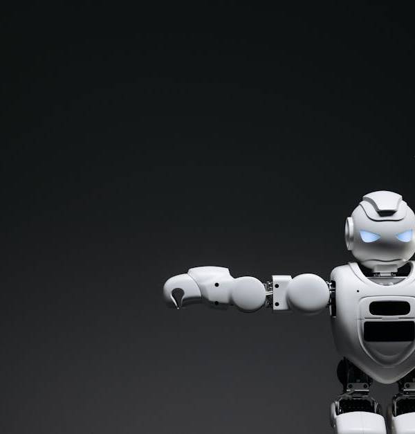 Studio shot of a humanoid robot with glowing eyes against a dark background, offering ample copyspace.