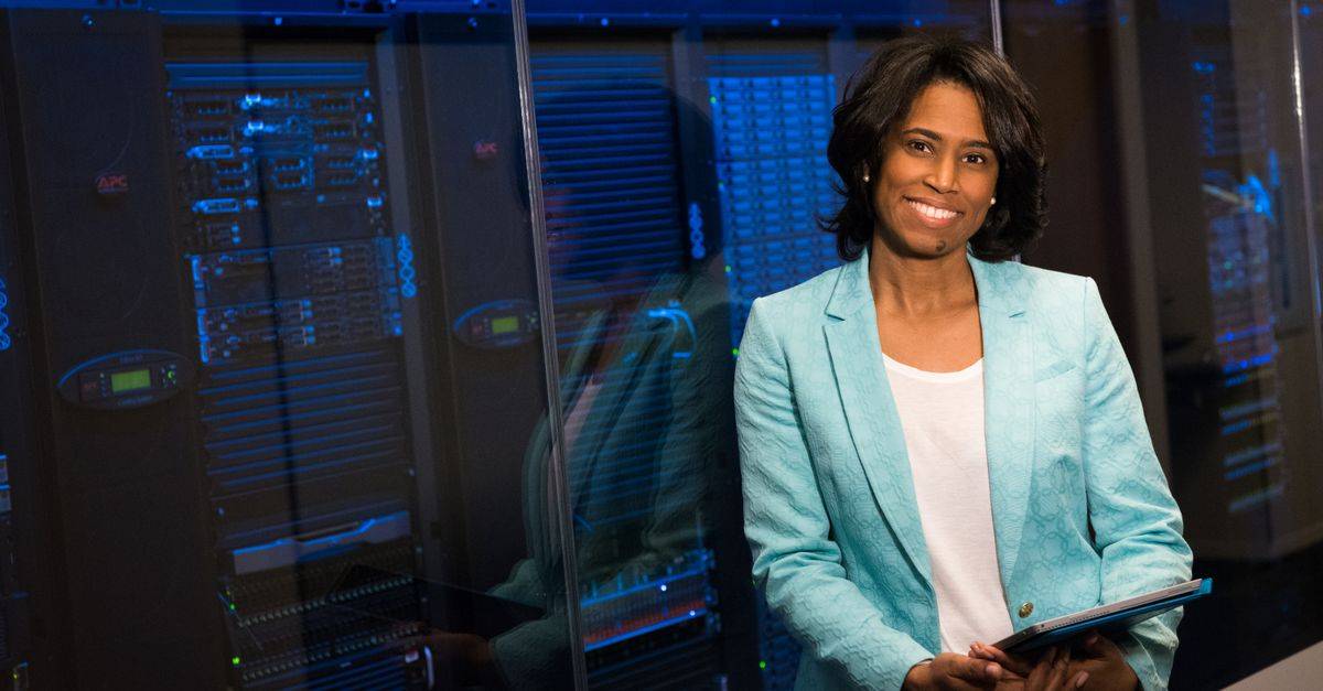 Smiling woman in data center showcasing technology expertise.