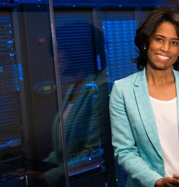 Smiling woman in data center showcasing technology expertise.