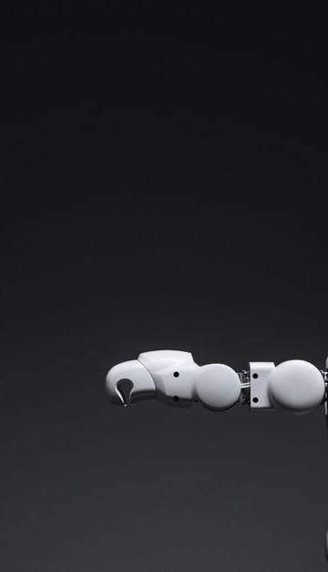 Studio shot of a humanoid robot with glowing eyes against a dark background, offering ample copyspace.