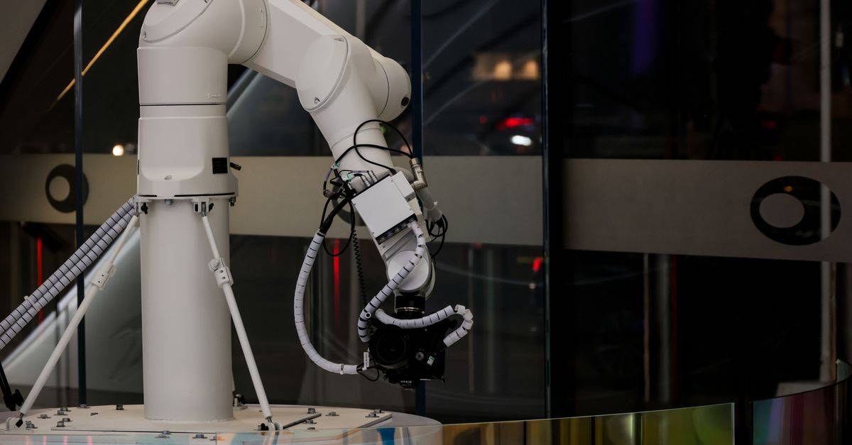 A white robotic arm operating indoors with a modern design and advanced technology.