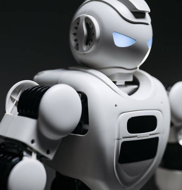 High-detail close-up image of a white robot with glowing eyes in studio lighting. Modern tech innovation.