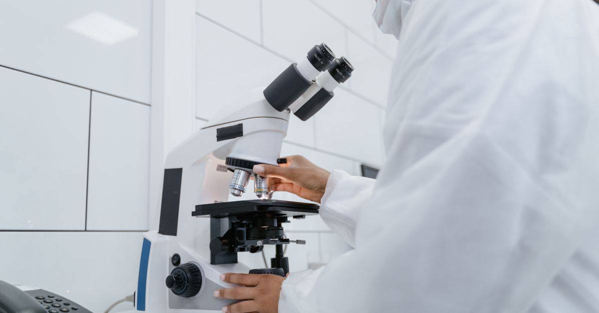 Scientist using microscope for research in a modern laboratory setting.