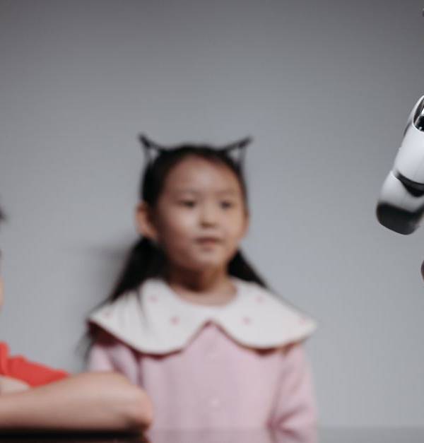 Two children watching and interacting with an innovative robot toy indoors.