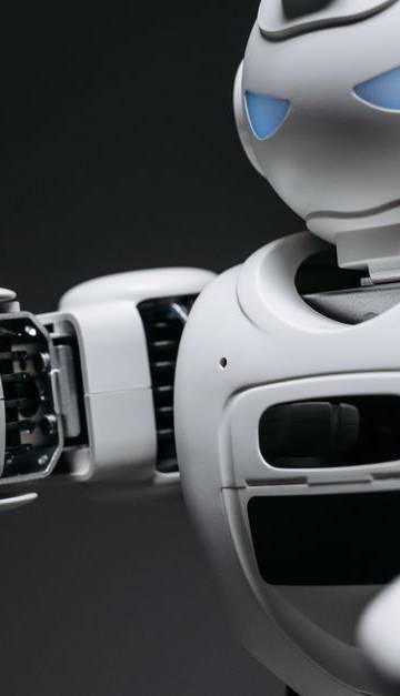 Detailed close-up of a high-tech white robot in a studio setting with a gray background.