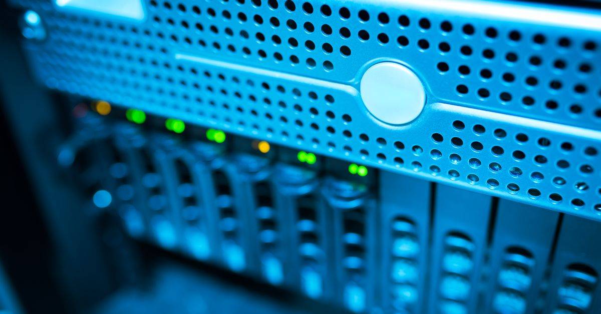 Focused view of a modern data server rack with blinking lights in a blue-lit environment.