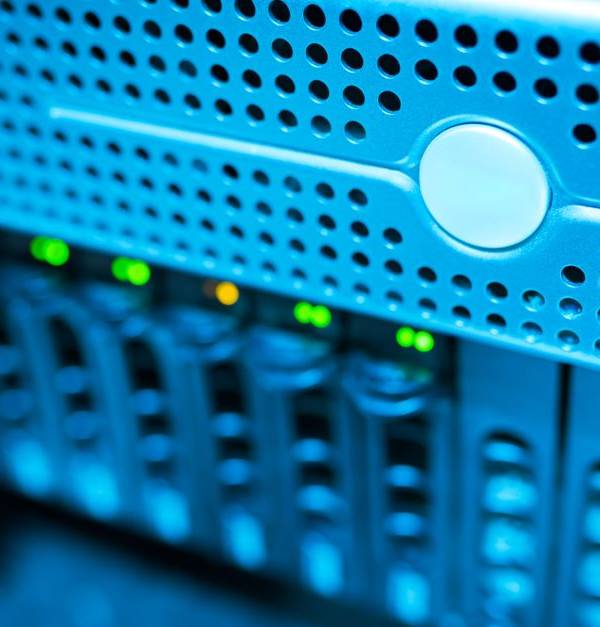 Focused view of a modern data server rack with blinking lights in a blue-lit environment.