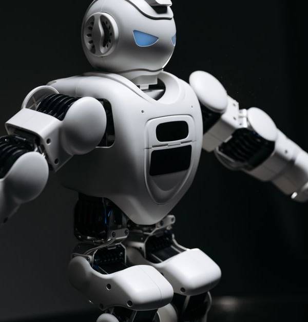 Close-up of a futuristic humanoid robot under dramatic lighting in dark ambiance.