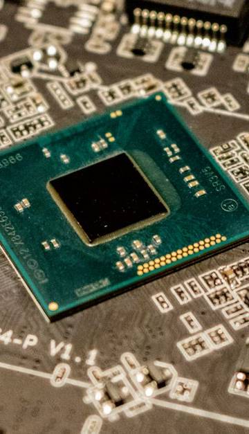 Detailed view of a microchip on a printed circuit board, showcasing electronic components.