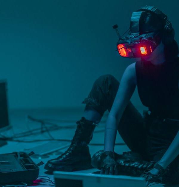 A person in a VR headset hacking in a moody, neon-lit environment.