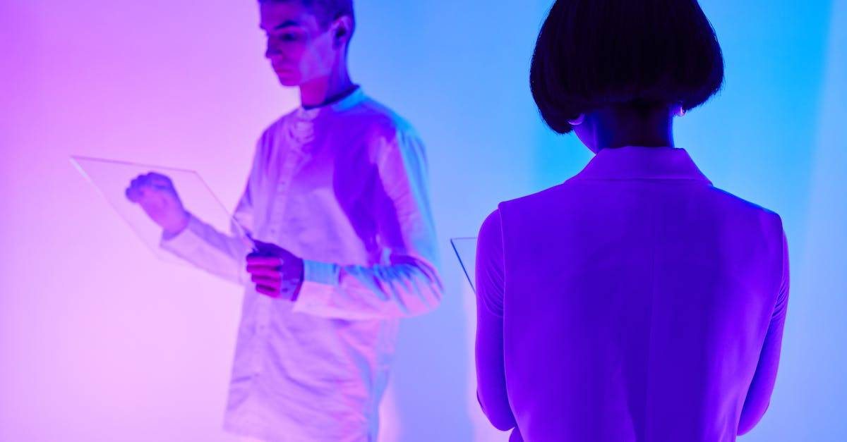 Two individuals interact with digital interfaces in a colorful futuristic setting.