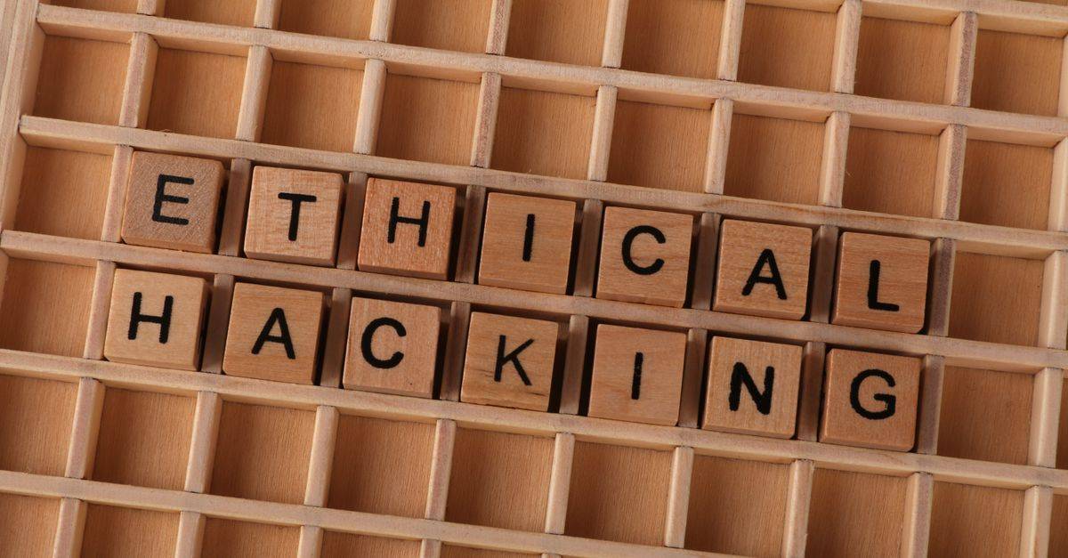 Wooden blocks spell 'ethical hacking', symbolizing cybersecurity concepts.