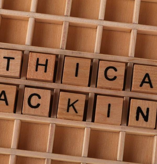 Wooden blocks spell 'ethical hacking', symbolizing cybersecurity concepts.