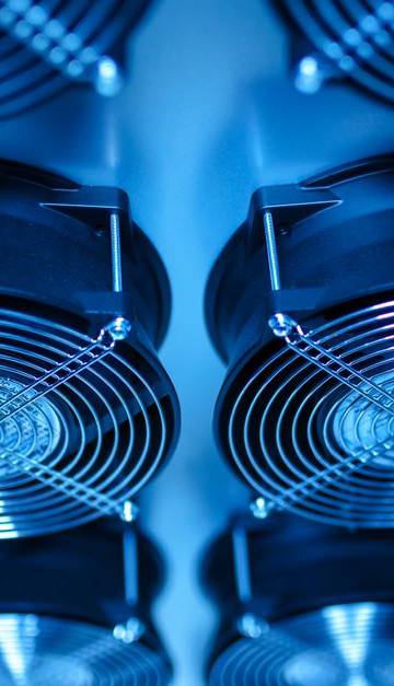 Close-up of cooling fans in a server room, showcasing technology and efficiency.