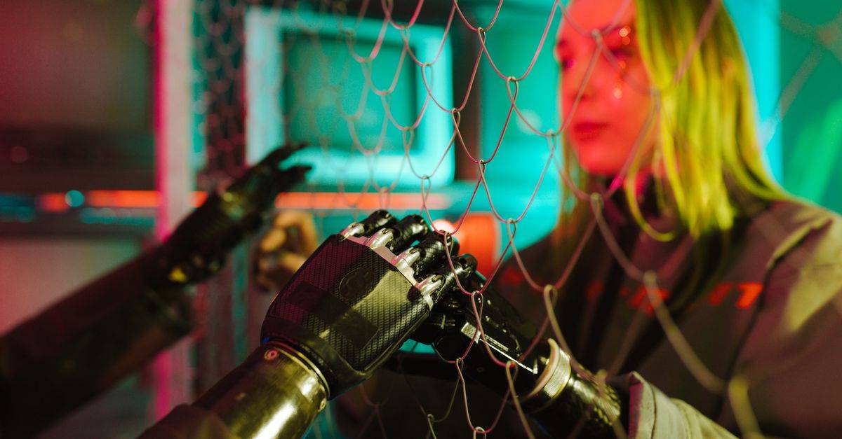A woman interacts with robotic hands through a mesh displaying a neon cyberpunk atmosphere.