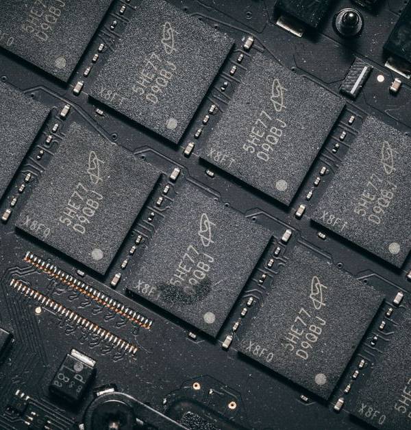 Detailed view of electronic circuit board components showcasing microchips and technology intricacies.