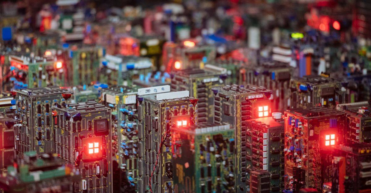 Close-up view of illuminated circuit boards resembling a cityscape, showcasing intricate electronic design.